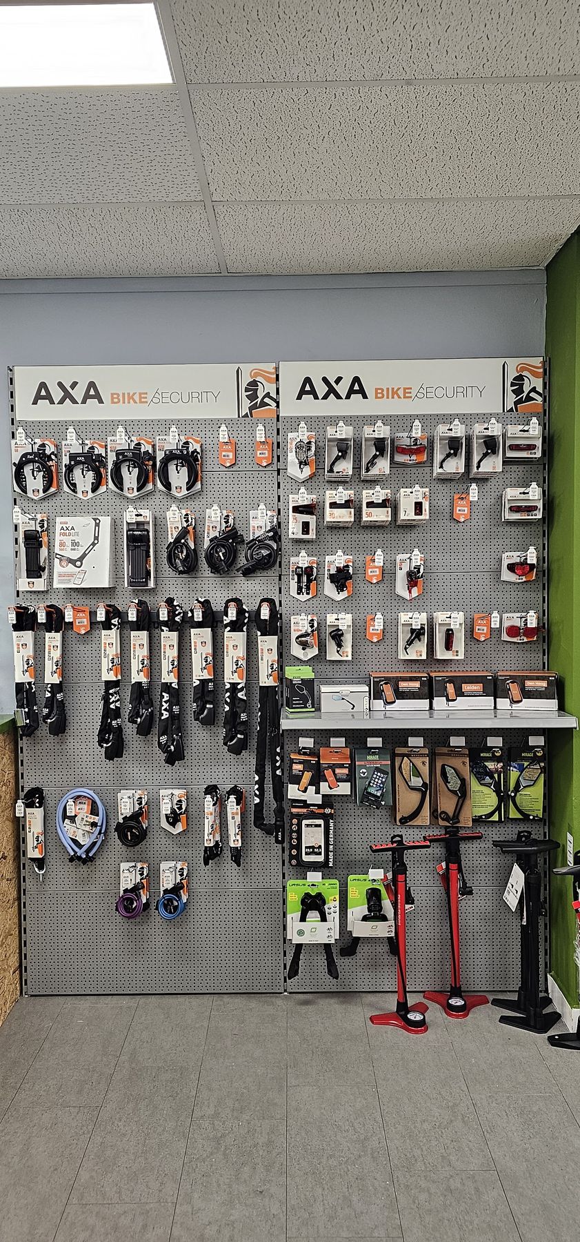 Wand met AXA fietssloten, kettingsloten en fietspompen