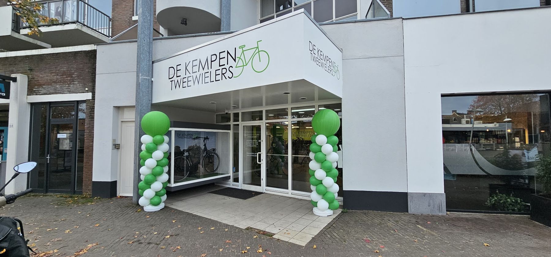 Gevel van De Kempen Tweewielers met het groen-zwarte logo op de luifel boven de ingang